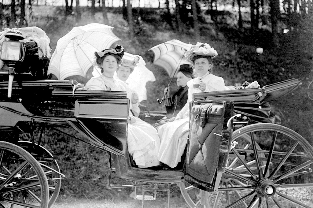 Damen mit Schrim in einer Kutsche, um 1900